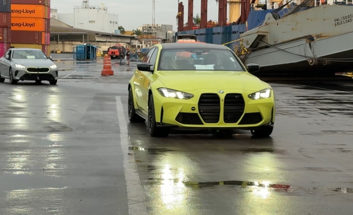 BMW M importado desembarcando no porto, com navio de carga ao fundo — importação independente pela Aurum Legacy